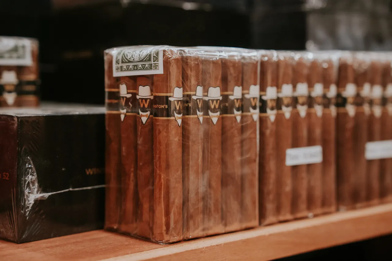 Bundles of Winston's signature cigars, each band printed with the hat and W, on a cedar shelf